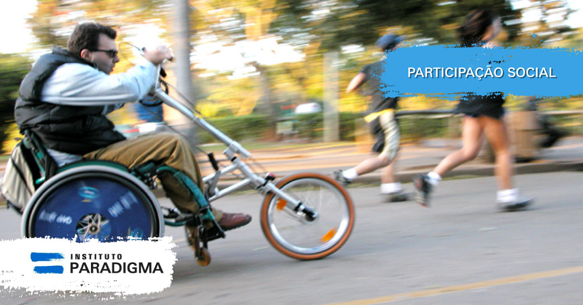 Cadeirante com handbike adaptada na cadeira de rodas, em movimento. Texto: Participação Social.