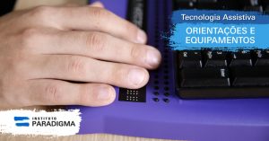 Mão sobre teclado de computador em Braille para cegos. Texto: Tecnologia Assistiva. Orientações e equipamentos.